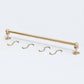 Solid unlacquered brass kitchen hanging rail set displayed flat on a white background with two end brackets and four S-hooks.