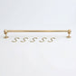 Solid unlacquered brass kitchen hanging rail displayed horizontally with five matching brass S-hooks on a white background.