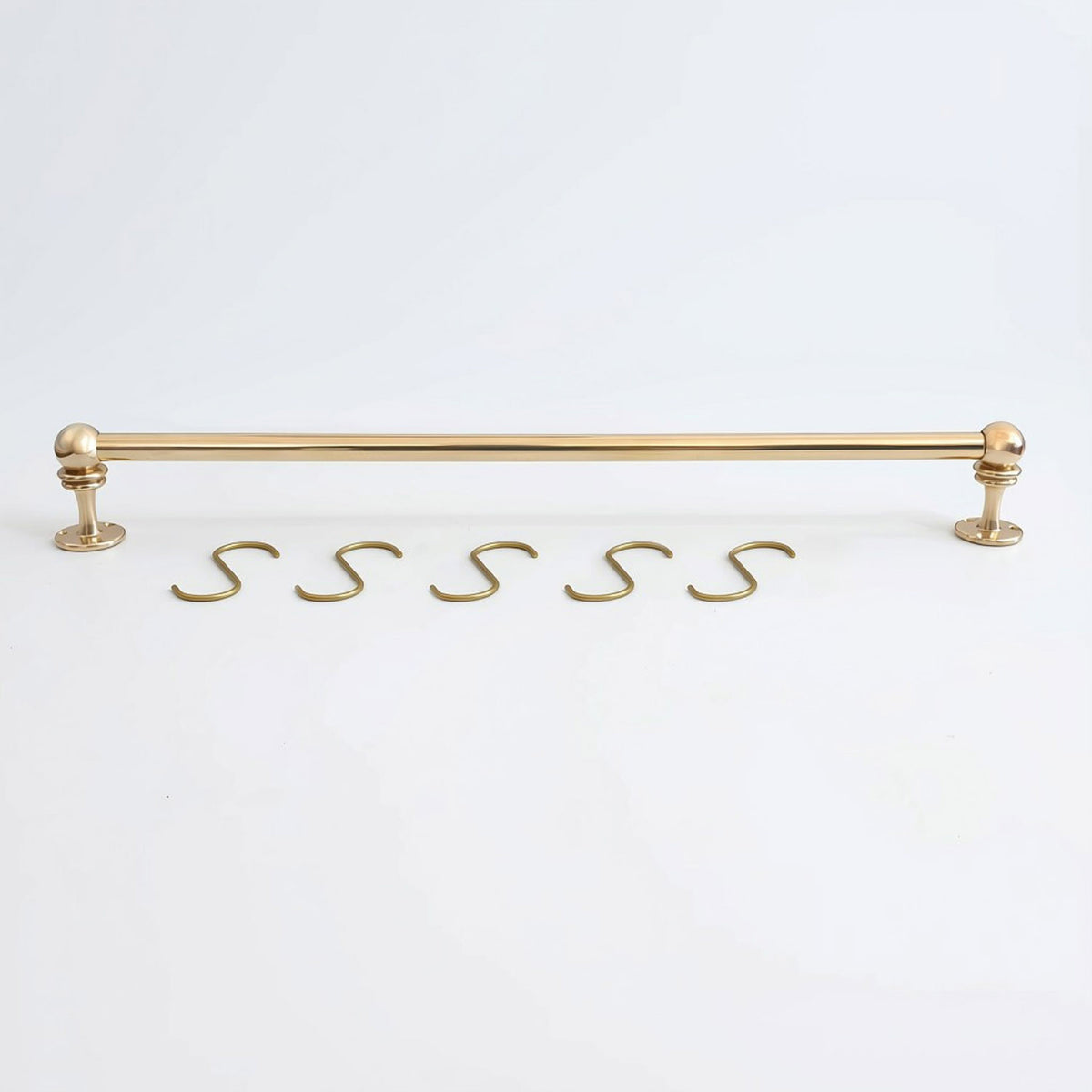Solid unlacquered brass kitchen hanging rail displayed horizontally with five matching brass S-hooks on a white background.